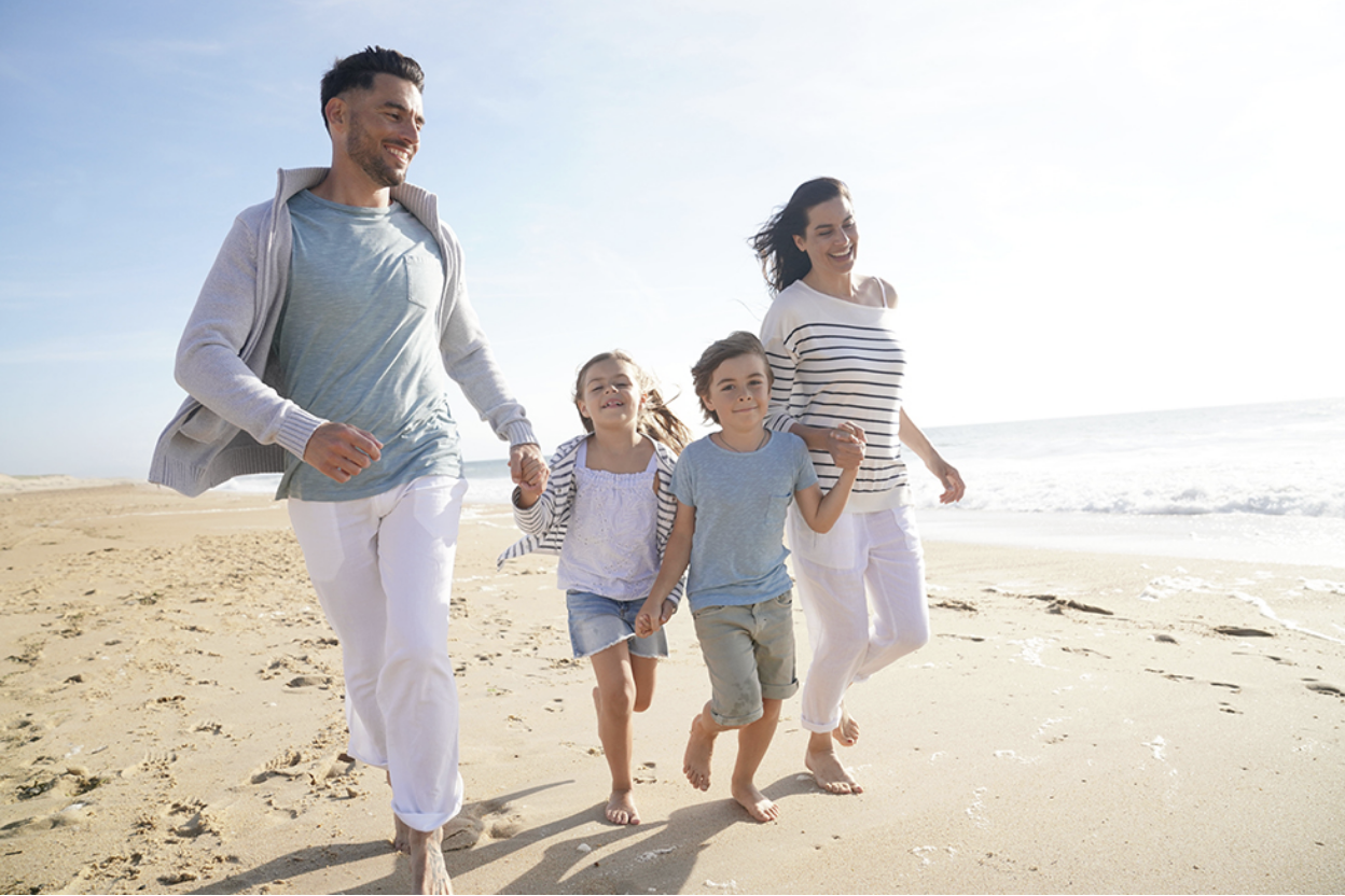 A family of four walking on the shore in Deerfield Beach A family of four walking on the shore in Deerfield Beach
