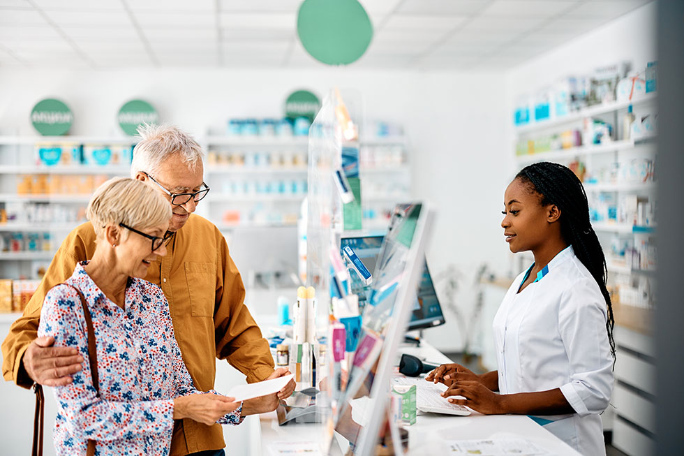 Senior couple buying prescription medicine in drugstore.